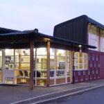 Front of The Eco Hub at dusk with the lights on inside