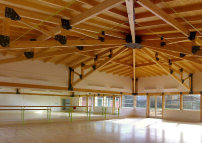 The Kingspan Hall - A bright square hall with wooden floors and stunning wooden rafters windows on three sides and a mirrored wall