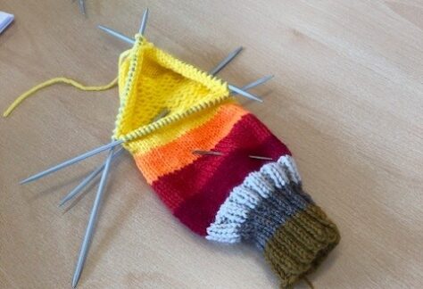 Colourful knitting on its needles